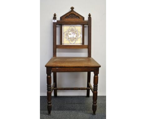 A 19th century Arts & Crafts oak hall chair inset with a Minton ceramic tile.