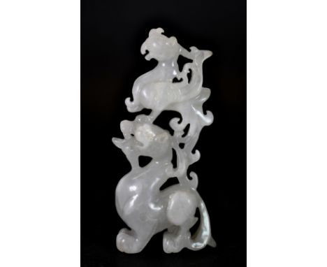 A very finely carved 19th/early 20thC Chinese white jade figure of a phoenix sitting on a dragons head, H. 9cm.