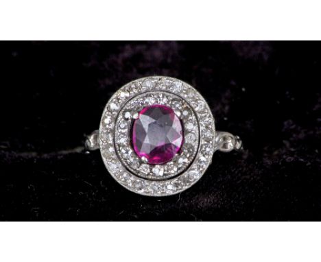 A platinum, ruby and diamond set ring
The oval cut Burmese natural red ruby spreading to approximately 1.3 carats within twin