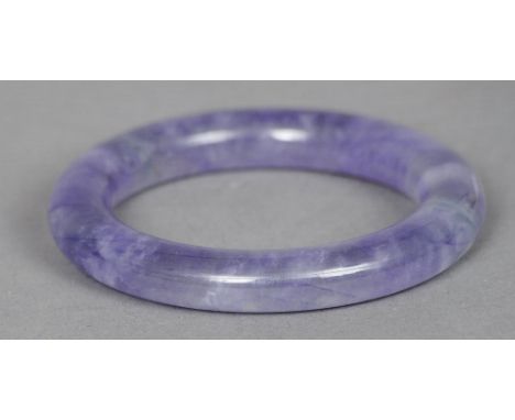 A Chinese carved lavender jade bangle
Of typical form.  8.5 cm diameter. CONDITION REPORTS: Generally in good condition, expe