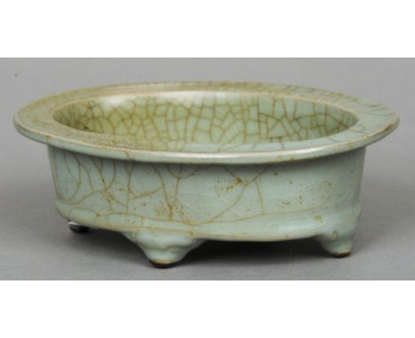 A Chinese celadon glazed planter
Of oval section, the underside inscribed with gilt calligraphic script.  21.5 cm wide. CONDI