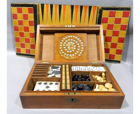 A 19th century mahogany games compendium
Enclosing: solitaire board and marbles, draughts pieces, chess pieces, dominoes, cri