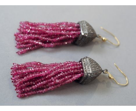 A pair of diamond and ruby set ear pendants
Each diamond encrusted body issuing ruby set tassels.  Each 6 cm high. CONDITION 