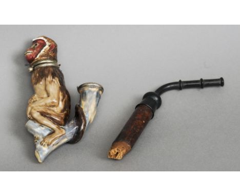 A late 19th century porcelain pipe
Formed as a seated monkey, the hinged head enclosing the bowl.  14 cm high. CONDITION REPO