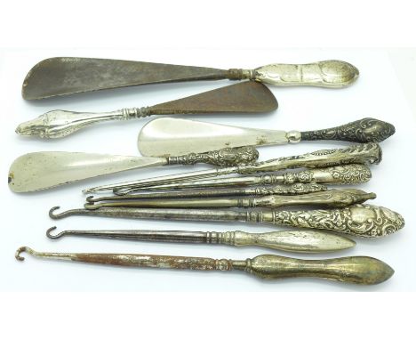 Four silver handled shoe horns and seven button hooks