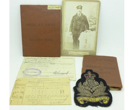 An Intelligence Corps uniform or blazer patch, a Soldiers' Service and Pay Book, a Skill at Arms Record Book and a cabinet ca