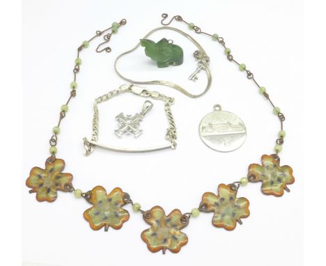 A silver ID bracelet, a silver medallion, a silver miniature cross, a jade elephant, a necklet and a silver bracelet