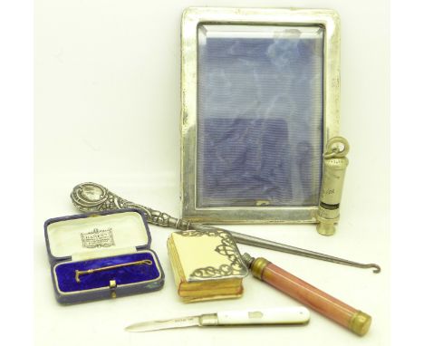 A silver photograph frame, a silver handled button hook, a policeman's whistle, a silver fruit knife, a scent bottle, a silve