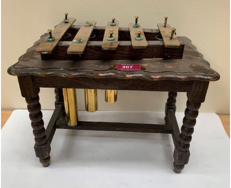 An oak and brass glockenspeil on bobbin turned supports. 13½' wide