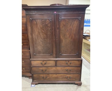 An 18th century mahogany linen press, the pair of doors enclosing four sliding trays, over two short and two long drawers on 
