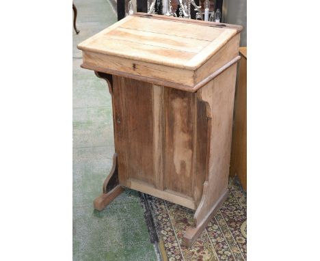 An oak schoolmasters desk, hinged top panel door cupboard to base 97cm high x 61cm wide 