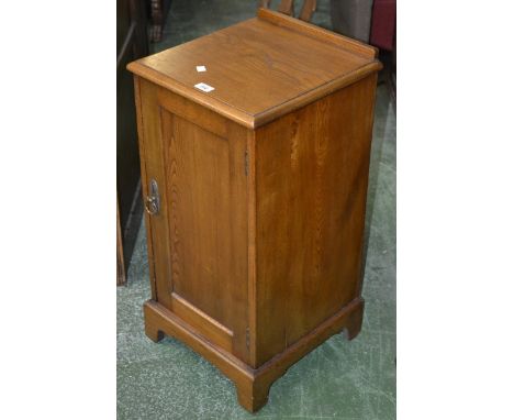 An ash bedside cabinet, galleried top, panel door