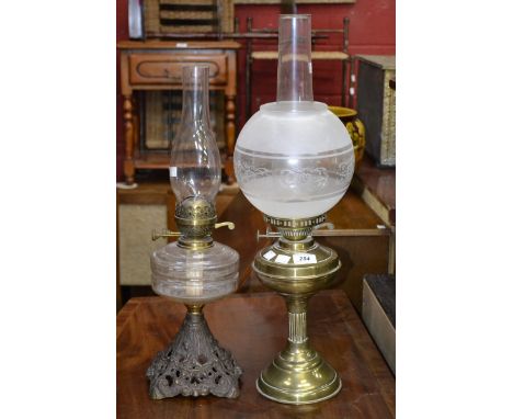 A Victorian cast iron oil lamp, clear glass reservoir; a brass oil lamp, twin burner, etched glass globular shade (2)