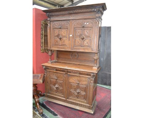 A French block fronted oak dresser, stepped cornice, shaped and carved frieze, two heavily carved doors top, turned supports,