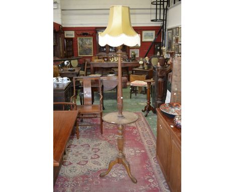 An early 20th century limed oak combination standard lamp and occasional table.