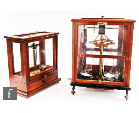 An early 20th Century mahogany cased set of balance scales by Oertling with glass flask accessories, height 49cm, a similar s