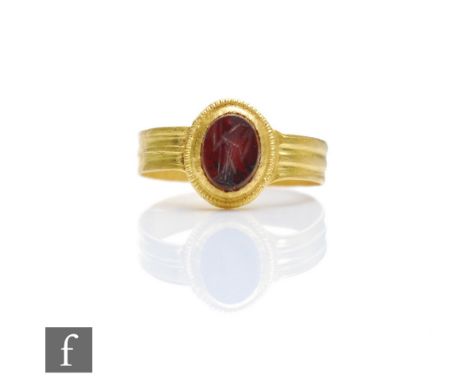 A Roman 2nd to 3rd Century 22ct gold finger ring, set with a carved carnelian intaglio of an image of a deity to a ribbed sha