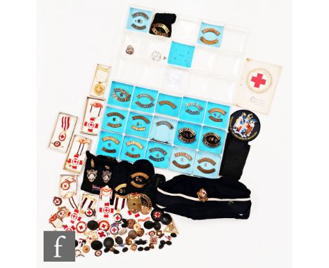A large collection of British Red Cross enamel badges, brass shoulder badges naming various counties and medals, some boxed w