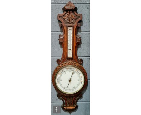 A Victorian carved oak aneroid barometer by C. Barley &amp; Son Worcester, incorporating a thermometer. 