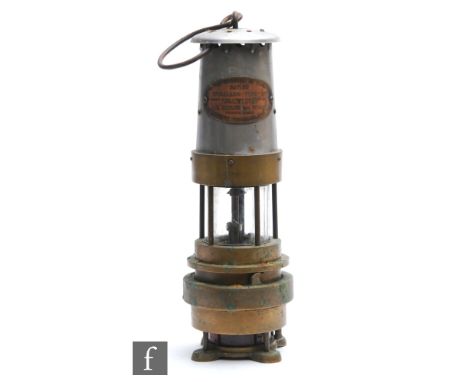 A brass miner's lamp with aluminium chimney and plaque named Naylor Spiralarm type ?M?, by L H Naylor Wigan, height 30cm. 