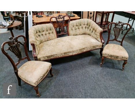 A Victorian carved mahogany three piece drawing room suite comprising a three seater button back settee and two matching chai