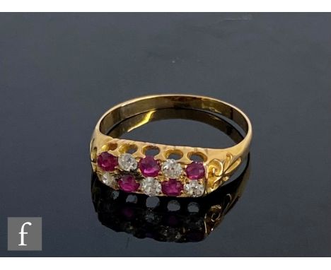 An early 20th Century ruby and diamond eight stone boat shaped ring, two rows of alternating stones to scroll shoulders, weig