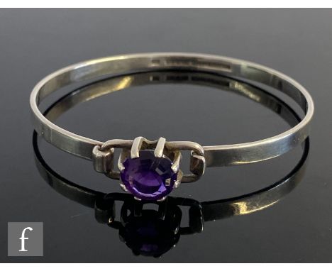 A 1970s Finnish silver stiff bangle detailed with single claw set amethyst to hinged clasp. 