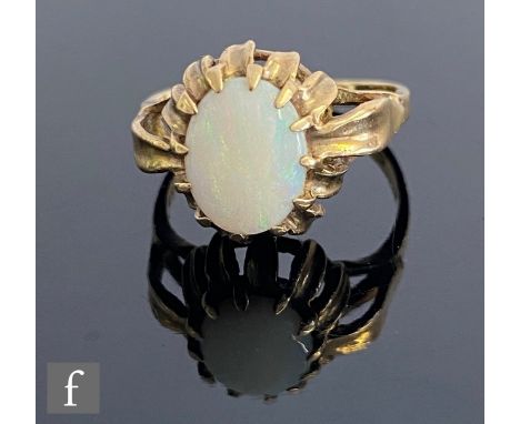 A 9ct hallmarked opal single stone ring, claw set oval stone to leaf set shoulders, weight 3.2g, ring size L 1/2. 