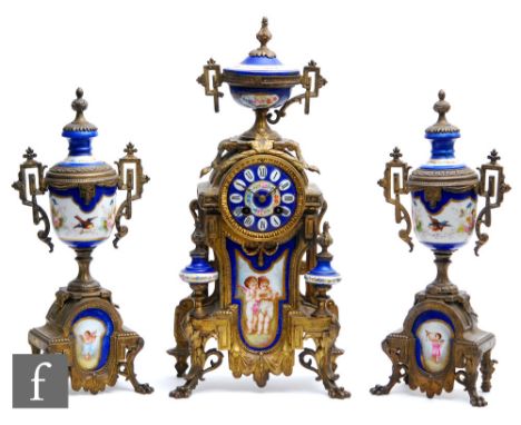 A late 19th Century French gilt metal clock garniture, the clock mounted with an urn over a blue enamelled dial and a panel p