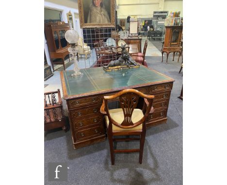 An early 20th Century mahogany partners desk with carved edge below a green tooled leather inset top over three frieze drawer