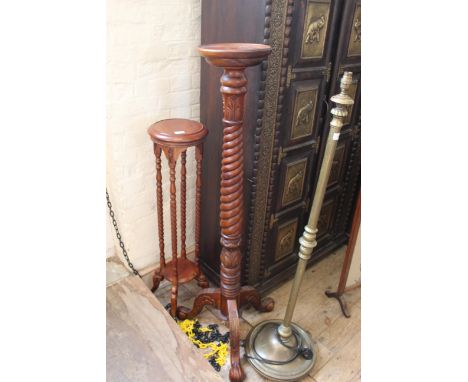A mahogany torchere with a twisted column on bold carved tripod legs