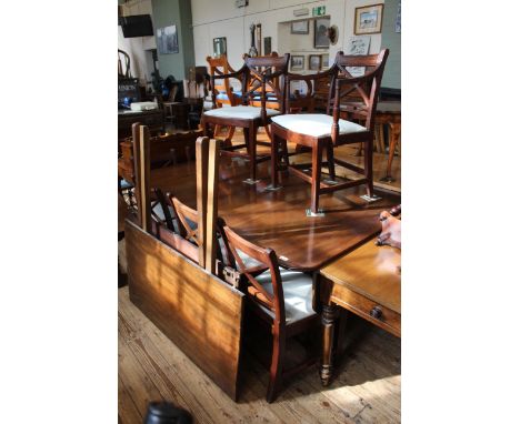 A Sheraton style mahogany two pillar table with leaves and a set of Sheraton style mahogany chairs (5 + 1)