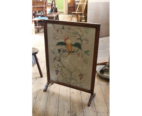 A 1920's needlework and oak firescreen