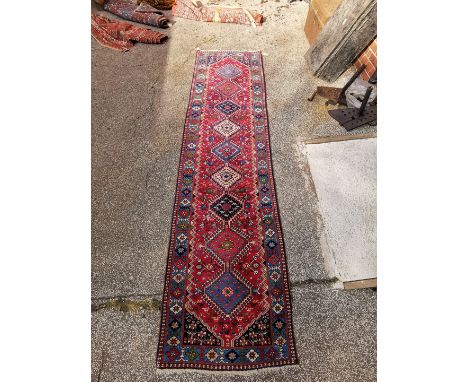 A multi coloured red ground wool runner, approx 300cm x 80cm