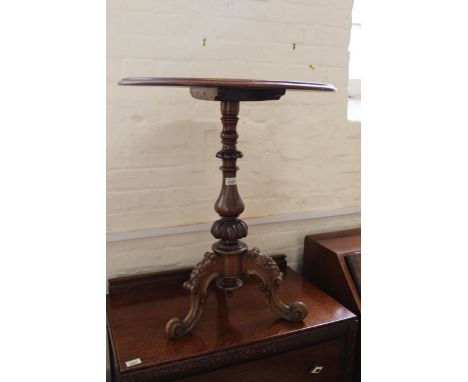 A Victorian walnut tripod table on carved tripod legs