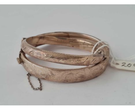 A engraved silver hinged bangle together with a small example