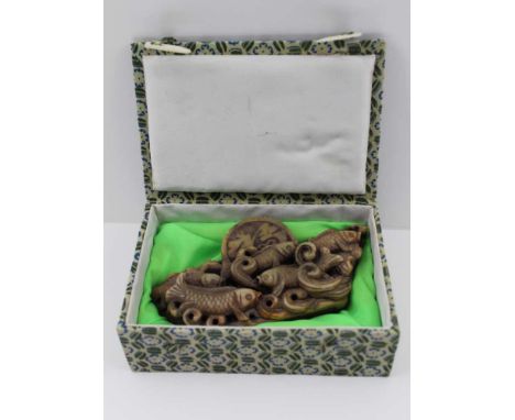 A CHINESE CARVED SOAPSTONE SEAL, relief carved with fish, engraved with script, 7.5cm high x 15cm wide, in fabric covered pre