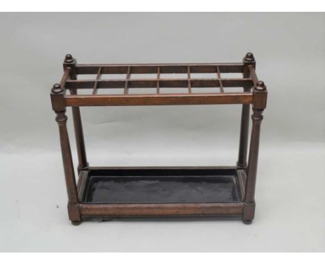 A FIRST-QUARTER 20TH CENTURY MAHOGANY FINISHED STICK STAND with multi-aperture top, supported on turned and blocked uprights,