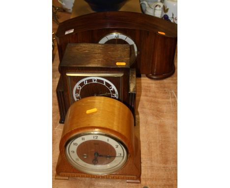 A 1950s walnut cased mantel clock, having a raised dial with Arabic numerals, eight day movement striking on a gong, w.43cm; 