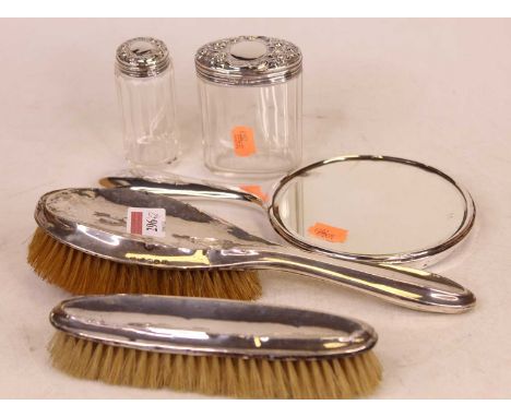 Two silver backed brushes; together with silver backed mirror and two silver topped dressing table jars 