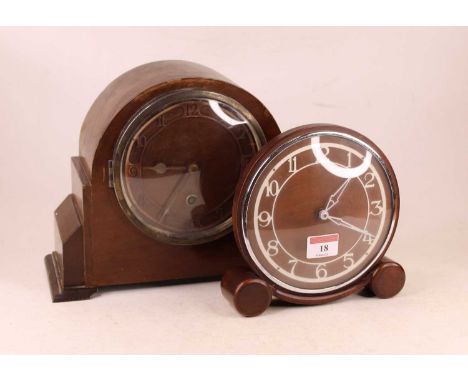 A 1950s oak cased mantel clock, having a circular dial with raised Arabic numerals, the bakelite case back marked Metamec Der