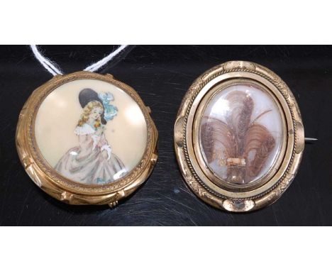 A Victorian pinchbeck mourning brooch, decorated with locks of hair under crystal; together with one other gilt metal cased m