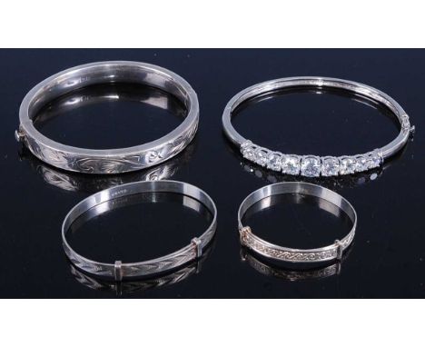 A modern hollow silver hinged bangle; together with two white metal christening bangles; and a white metal cz set hinged bang