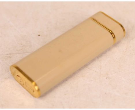A Cartier pocket cigarette lighter, the cream case with gilt banding, numbered 27606G