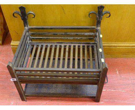 A wrought iron vintage-style dog grate with cinder tray