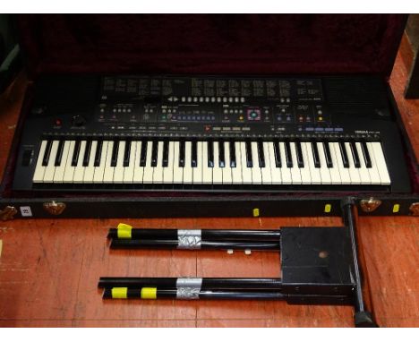 A Yamaha PSR-410 battery operated piano accordion with a small portable stand
