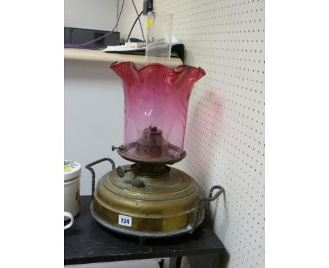 A Victorian, brass reservoir  base oil lamp with cranberry glass shade