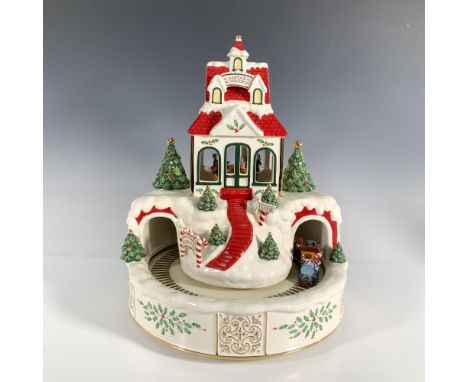 This centerpiece offers a glimpse into the magic and wonder of Santa's workshop. Take a peek through the window to see Santa 