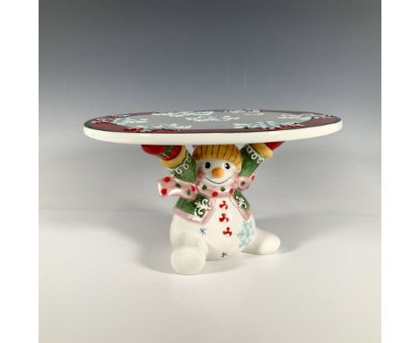 Hand crafted ceramic serving platter being held up by an adorable snowman. He is dressed in a green and pink sweater with yel