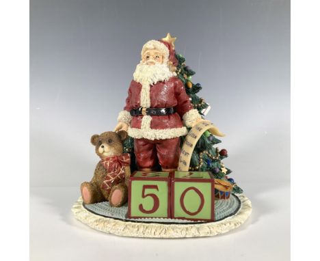 This colorful and whimsical ceramic calendar depicts Santa with his list standing in front of a Christmas tree laden with dec